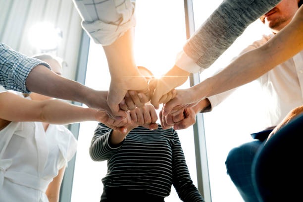 Ein Team bringt seine Hände als Zeichen der Zusammenarbeit zusammen